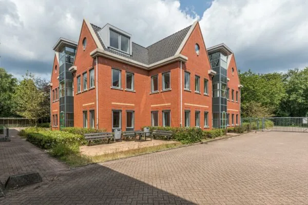 Modern rood bakstenen kantoorpand aan de Laan Blussé van Oud-Alblas met grijze raamkozijnen en glazen trappenhuis.